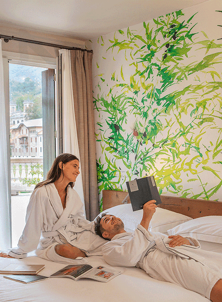 Coppia che legge sul letto dell'hotel di San Pellegrino.
