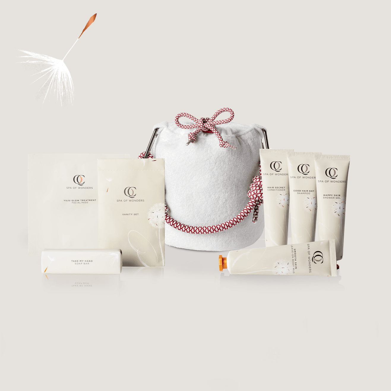 Pochette in spugna con 7 prodotti per la cura dei capelli, del corpo e delle mani, etichette frontali visibili, sfondo neutro.
