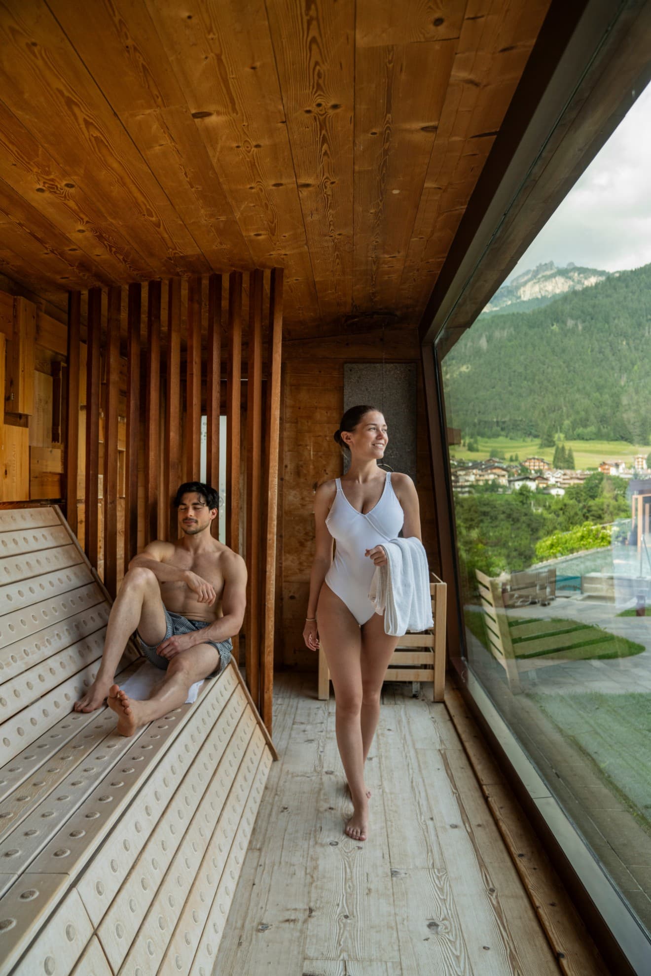 Coppia in sauna con vista sulle montagne.