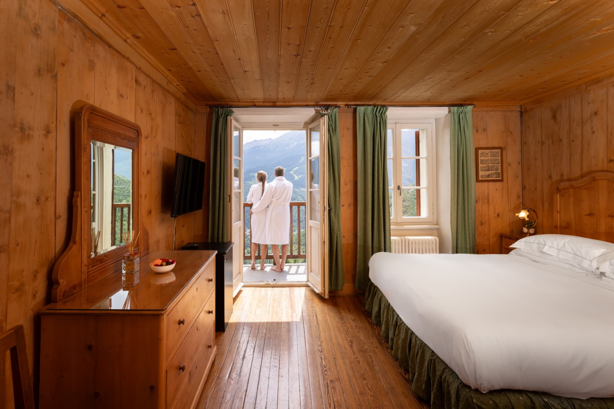 Wellness journey Panoramica di una stanza di hotel in montagna e coppia sul balcone.