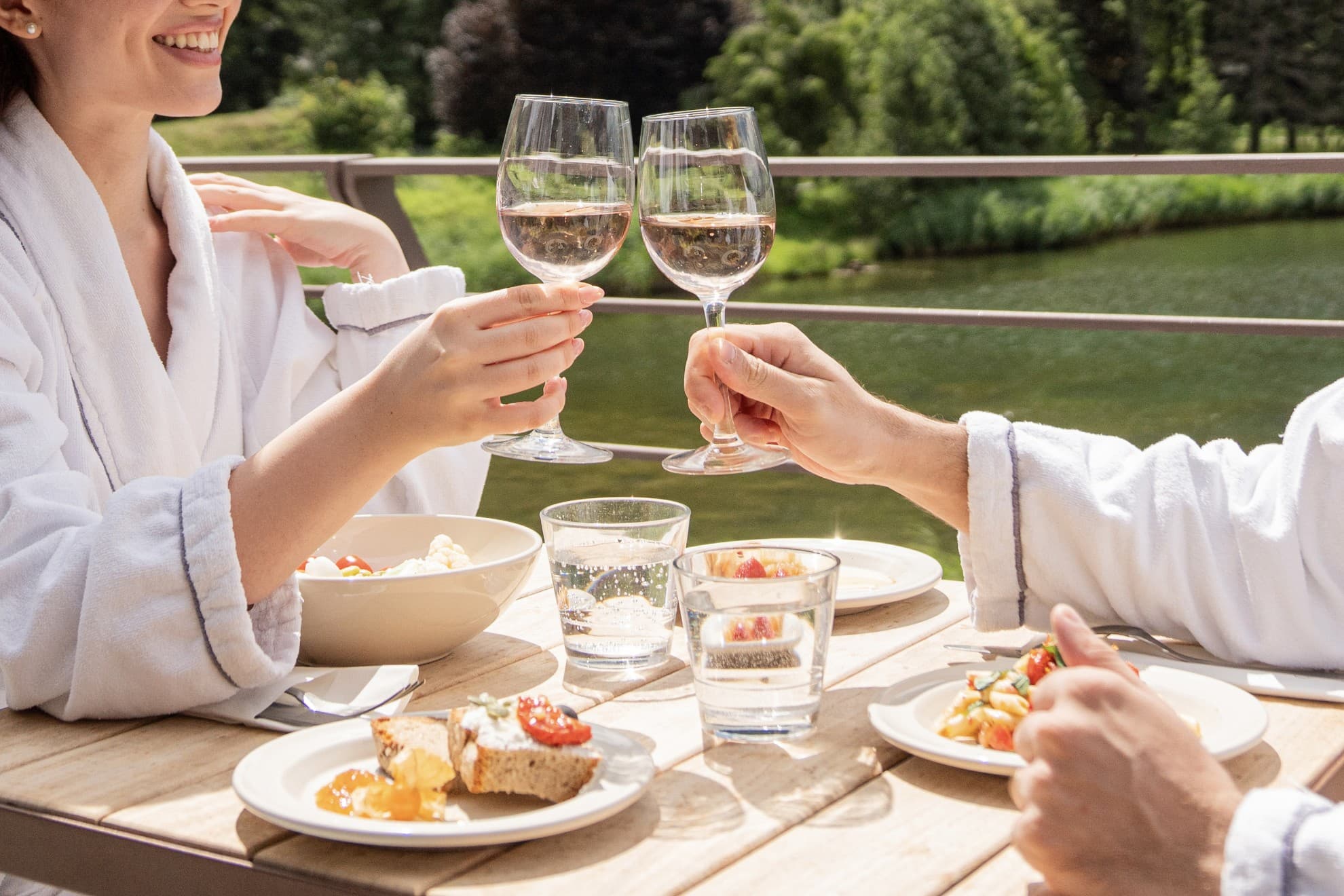 Wellness lunch Coppia che brinda con un calice di vino in accappatoio.